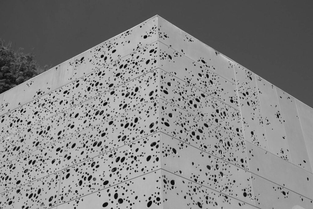 grayscale shot building facade with lots spots 1